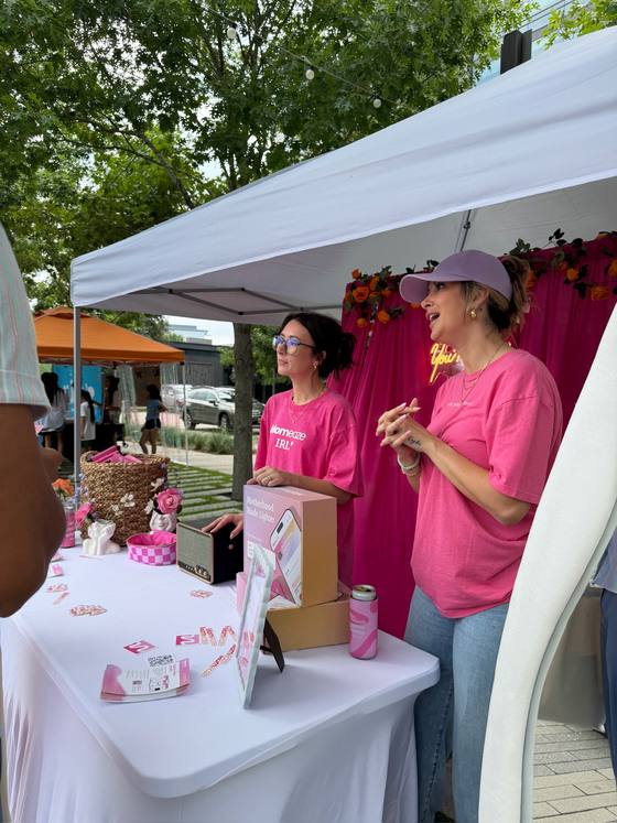 Two of the team working the Momeaze pop-up tent, talking to a visitor