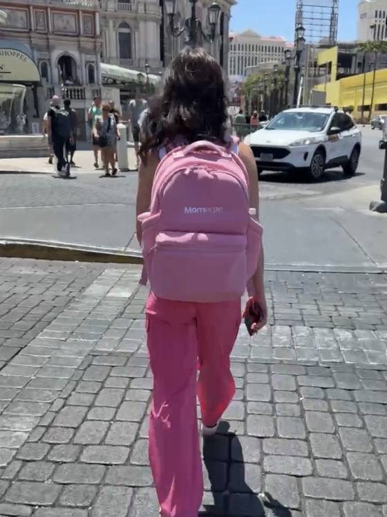 A pink Momeaze backpack, worn walking down the street on a work trip