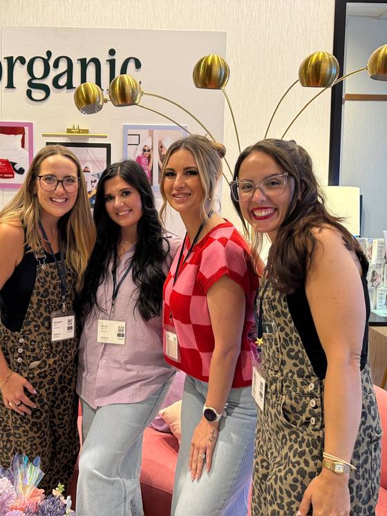 Four of the team arm in arm at a conference booth