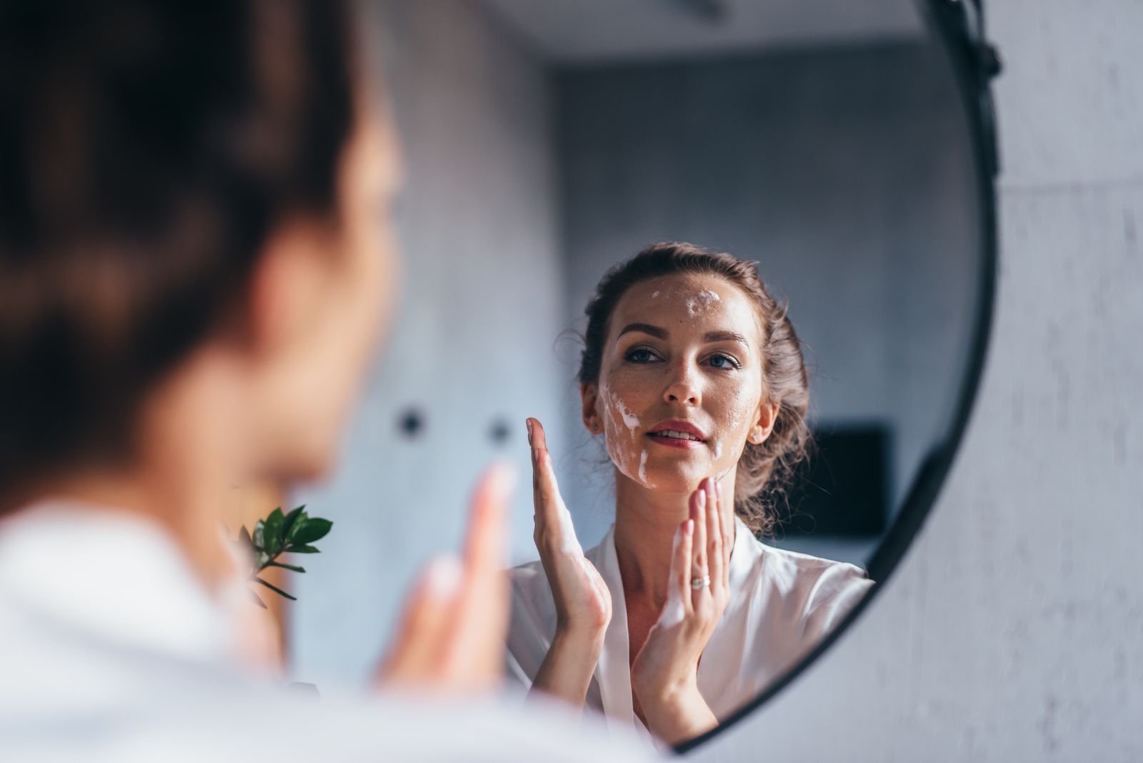 A woman taking a quiet moment at the bathroom mirror